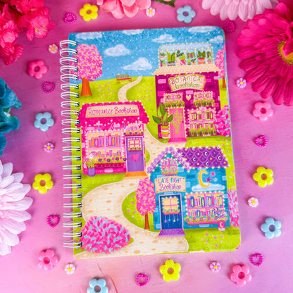 Bookshop Avenue spiral notebook on a pink backdrop