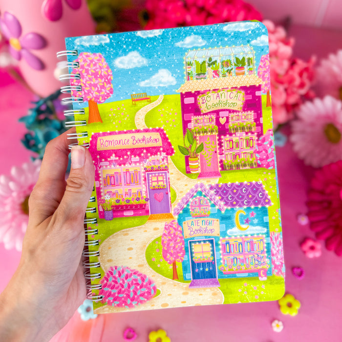 Bookshop Avenue spiral notebook on a pink backdrop