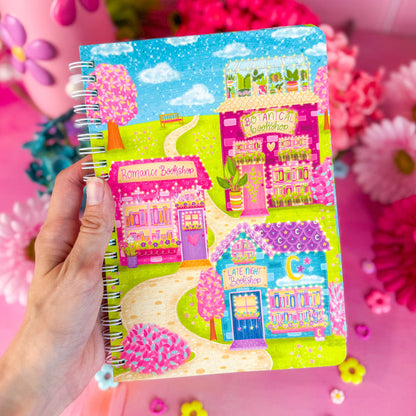 Bookshop Avenue spiral notebook on a pink backdrop