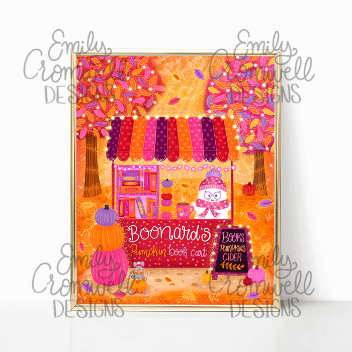 An art print of a ghost standing at a book cart surrounded by purple pink and orange pumpkins and leaves. The art print is in a shiny gold frame against a white background.