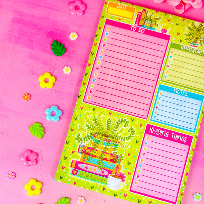 A notepad with sections for a to do list, important items, notes, and reading things. Featuring a green plant in the lower left corner and spring themed books and hearts around the border.