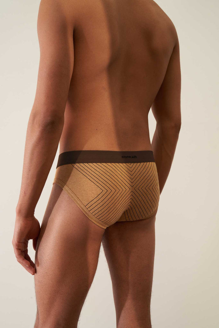 Rear view of tailored organic cotton rib brief in camel with brown cross and waistband, showcasing comfort and style.
