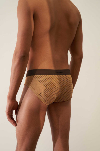 Rear view of tailored organic cotton rib brief in camel with brown cross and waistband, showcasing comfort and style.