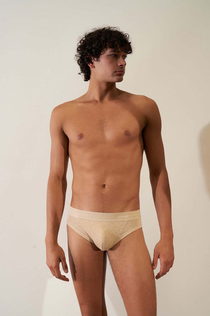 Organic cotton brief in sand color with orange cross, showcasing comfort and non-toxic materials.