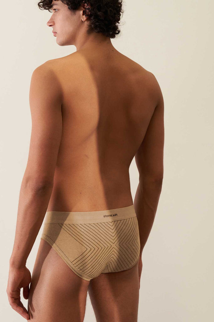 Organic cotton rib brief in Sand color, showcasing comfort and a GOTS certified design on a male model's back.