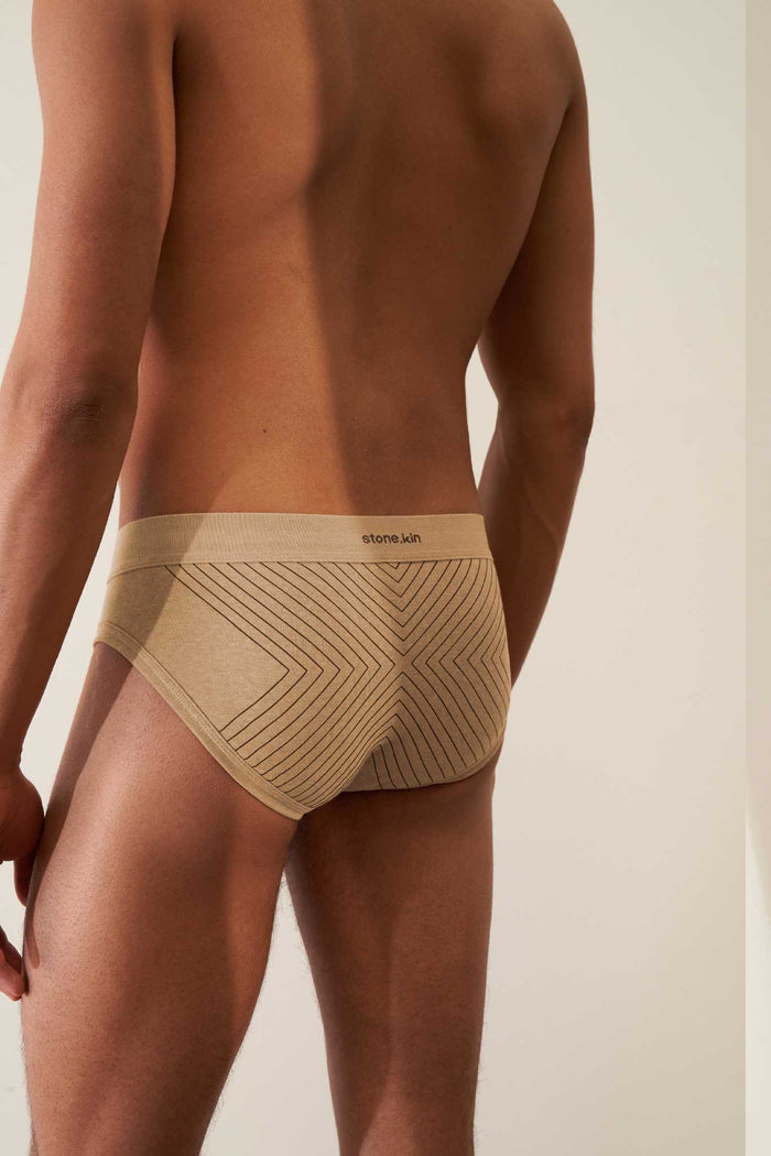 Stylish men's brief in organic cotton rib, sand color with tar cross, offering comfort and GOTS certification.