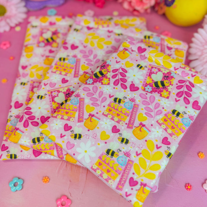 Colorful bee book sleeve on a pink background