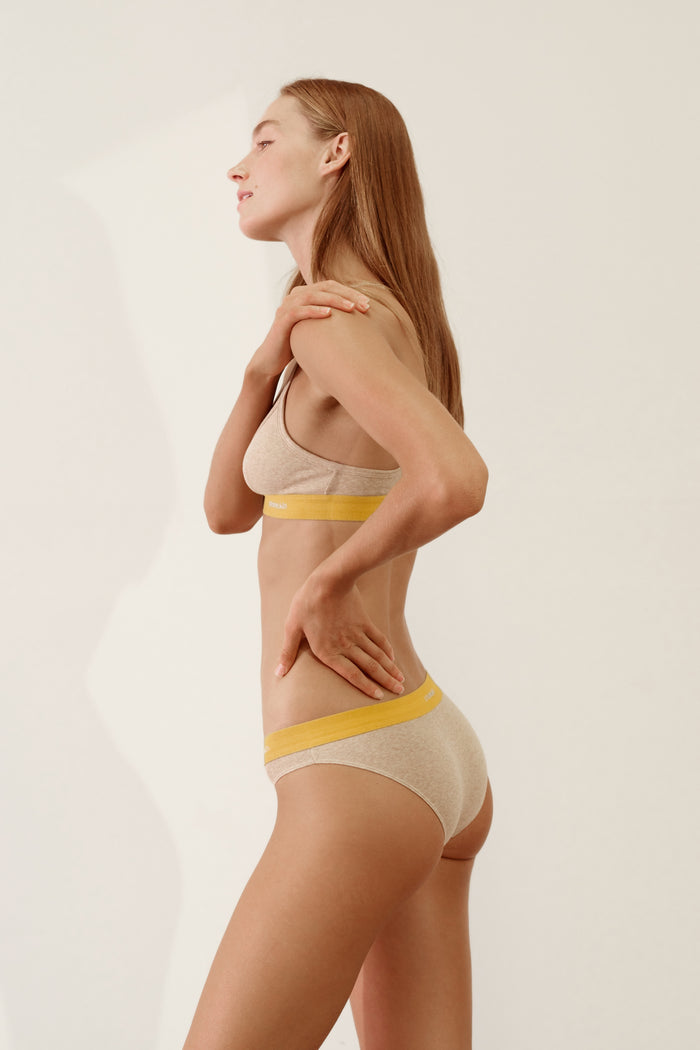 Cheeky in Organic Cotton Rib - Sand / Mustard bikini on model, showcasing natural stretch and comfort.