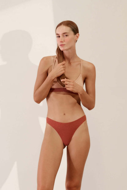 Model wearing Hi Thong in Organic Cotton Rib - Rust, showcasing its high-line sporty cut and comfort.