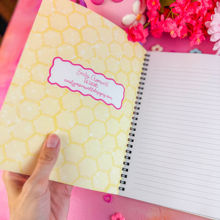 Notebook with honeycomb design and pink flowers on a pink background