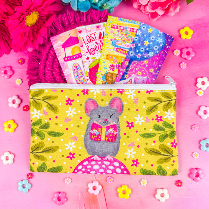 A white zippered fabric pouch. The pattern on the pouch features a mouse holding a pink book against a chartreuse background decorated with pink and white flowers and green leaves.