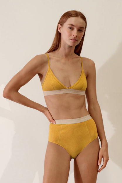 Model wearing a Scoop Back Bralette in Organic Cotton Rib - Mustard / Sand, featuring soft fabric and a stylish design.