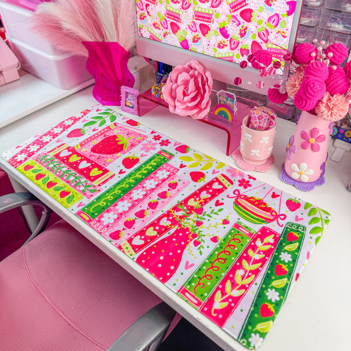 Strawberry bookshelf desk mat on a desk with pink decor