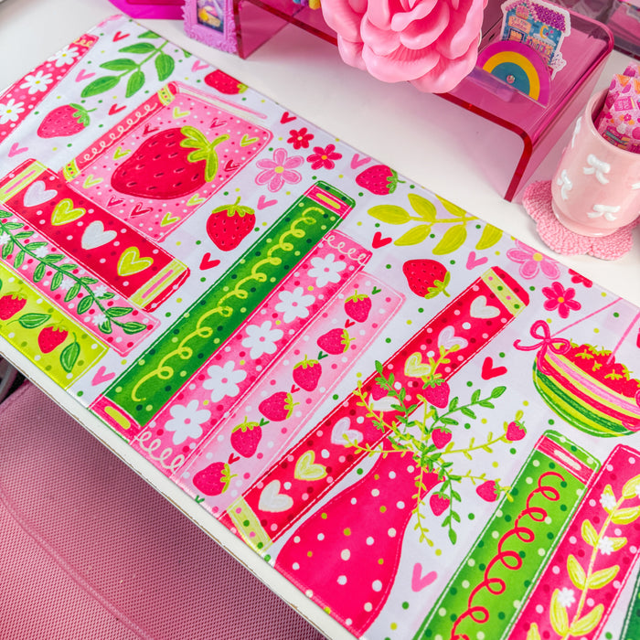 Strawberry bookshelf desk mat on a desk with pink decor