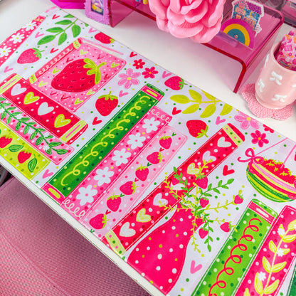 Strawberry bookshelf desk mat on a desk with pink decor
