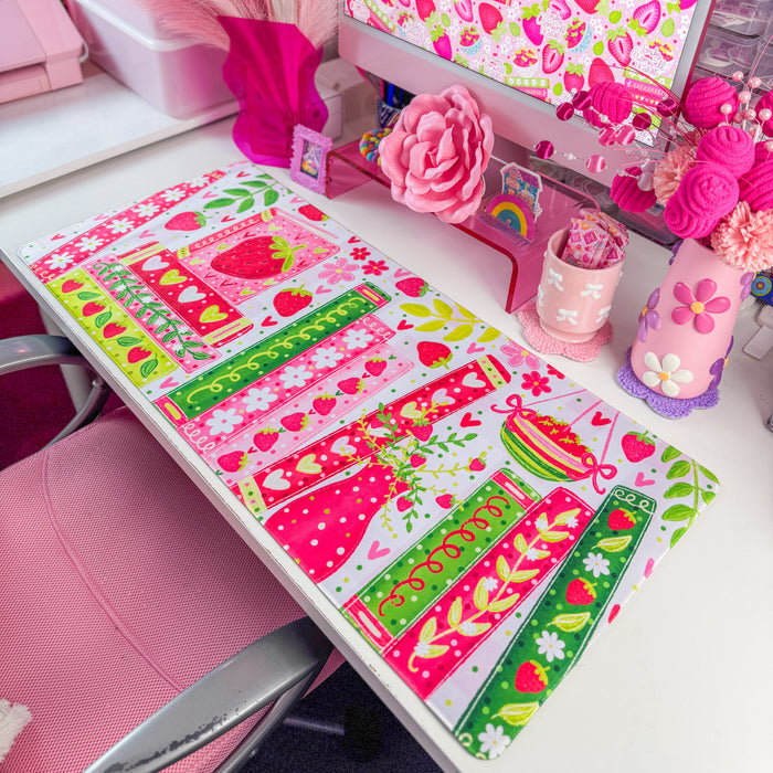 Strawberry bookshelf desk mat on a desk with pink decor