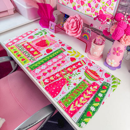 Strawberry bookshelf desk mat on a desk with pink decor
