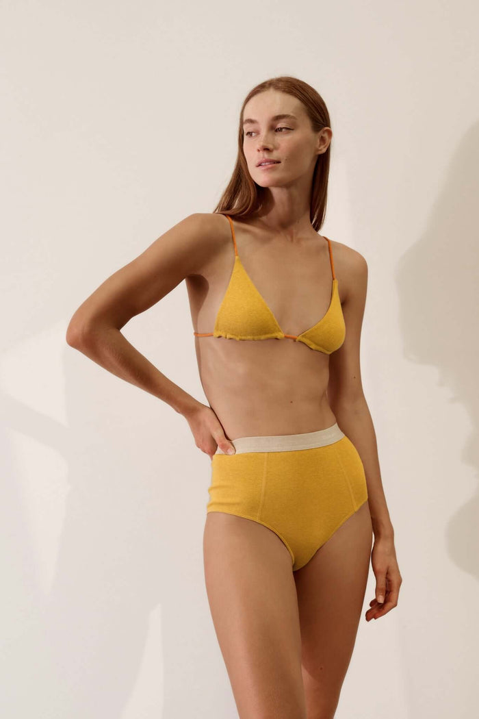 Triangle Bralette in Organic Cotton Rib - Mustard / Papaya styled with high-waisted briefs, showcasing softness and smooth texture.